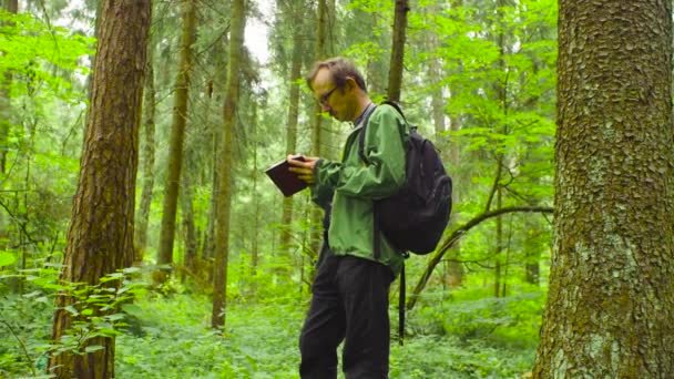 Эколог в лесу пишет в блокноте . — стоковое видео
