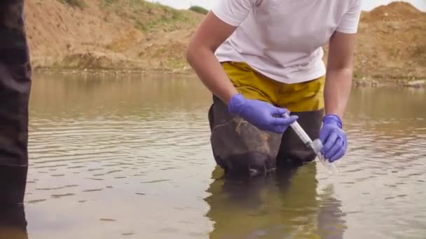 Žena ecologist, odběr vzorků vody — Stock video