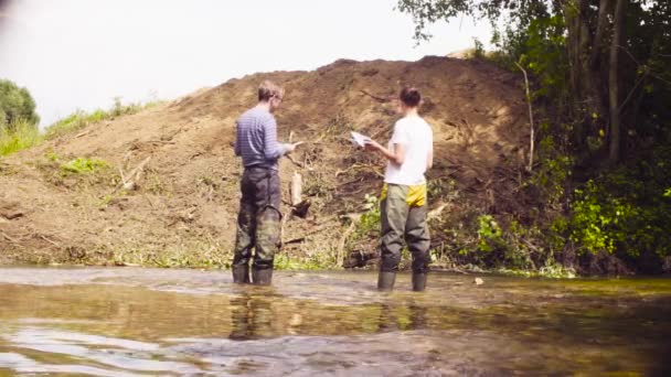 Dos ecologistas comprobando con el navegador GPS — Vídeo de stock