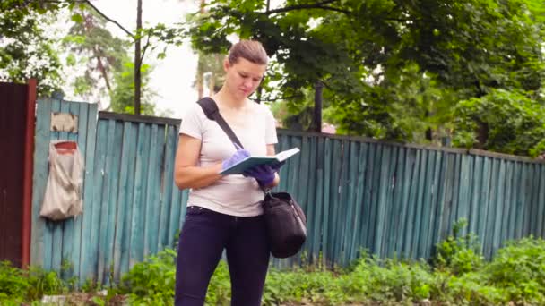 Ekolog, stojící poblíž smetišti a psaní — Stock video