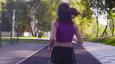 Genç bayan stadyumda koşuyor.