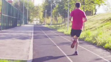 Yolda koşucular için stadyumda koşan adam