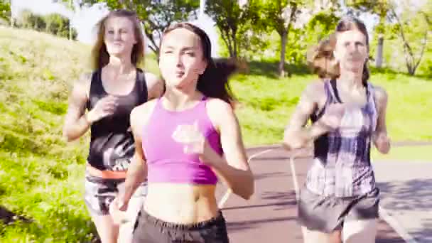 Tres jóvenes corriendo en el campo de deportes — Vídeo de stock