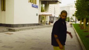 Genç adam bir şehir sokak üzerinde bir kaykay üzerinde paten