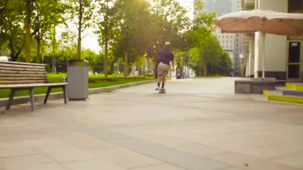 Young man skating on a skateboard on a city street — Stock Video