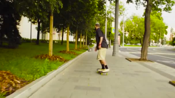 Joven patinando en un monopatín en una calle de la ciudad — Vídeos de Stock