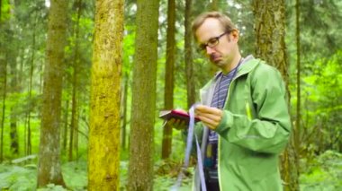 Ekolojist bir ormandaki bir ağaç gövdesi ölçme