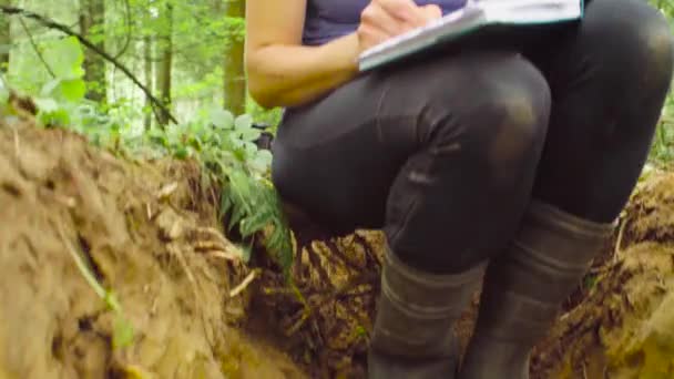 Woman ecologist writing in notebook — Stock Video