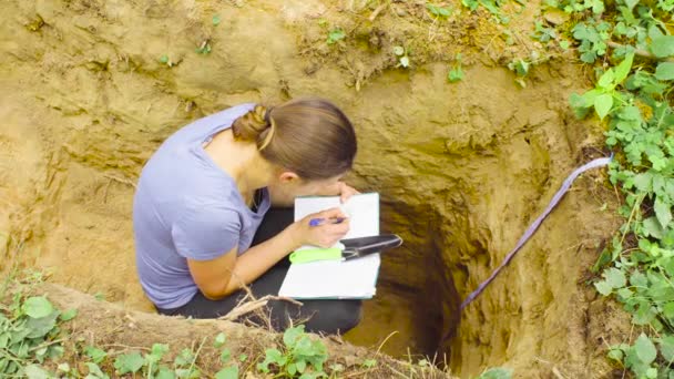 Woman ecologist writing in notebook — Stock Video