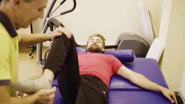 Médico fazendo exercícios de perna para homem com deficiência — Vídeo de Stock
