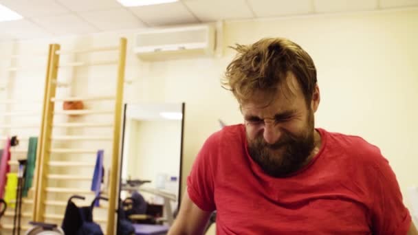 Лицо мужчины во время занятий в реабилитационном центре — стоковое видео
