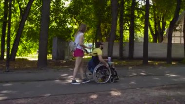 Genç adam parkta bir yürüyüş üzerinde eşi ile devre dışı bırakma