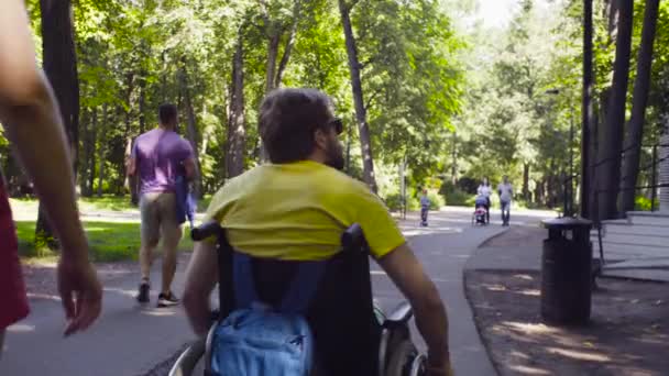 Junger behinderter Mann mit seiner Frau bei einem Spaziergang im Park — Stockvideo