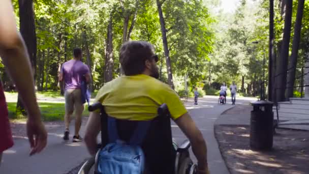 Joven hombre incapacitado con su esposa en un paseo por el parque — Vídeo de stock