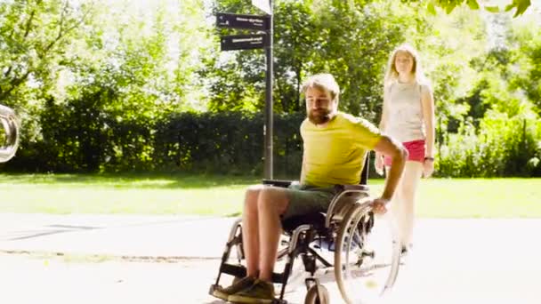 Jonge uitschakelen man met zijn vrouw op een wandeling in het park — Stockvideo