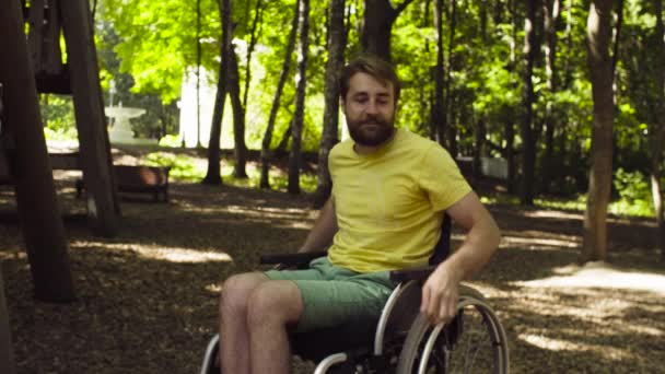 Joven hombre incapacitado con su esposa en un paseo por el parque — Vídeos de Stock