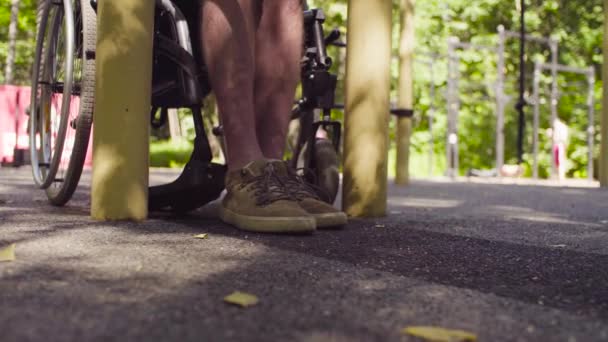 Beine eines behinderten Mannes im Rollstuhl — Stockvideo