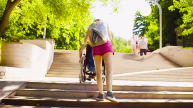 Devre dışı bırak adam tekerlekli sandalyede merdivenlerden aşağı hareket ediyor