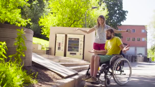 Молодой инвалид на прогулке в парке с женой — стоковое видео