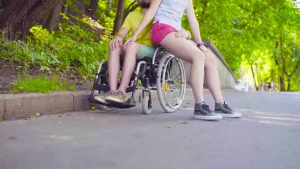 Jovem homem incapacitado em um passeio no parque com sua esposa — Vídeo de Stock