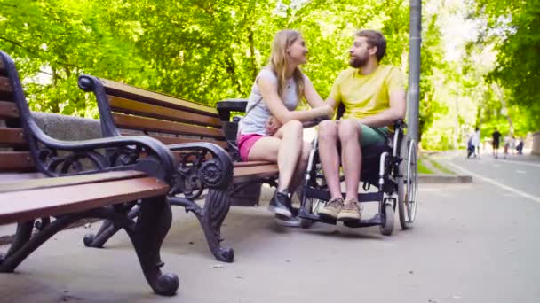 Jovem homem incapacitado com sua esposa no parque — Vídeo de Stock