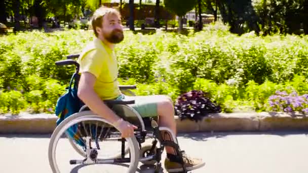 Молодой инвалид в инвалидной коляске в парке — стоковое видео