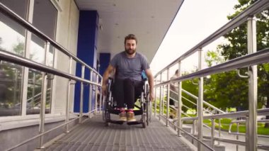 Yokuş aşağı sürme tekerlekli sandalyeli Engelli bir adam