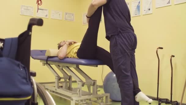 Врач помогает спортсмену в реабилитационном центре — стоковое видео