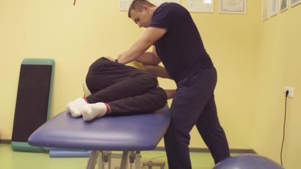 Doctor helping sportsman at the rehabilitation center — Stock Video