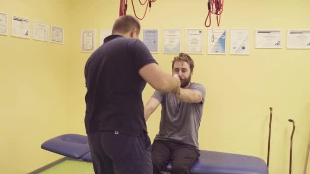 Médico que ajuda desportista no centro de reabilitação — Vídeo de Stock