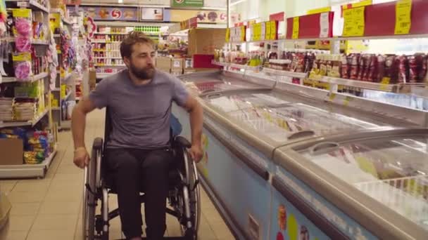 Un disabile in sedia a rotelle al supermercato — Video Stock