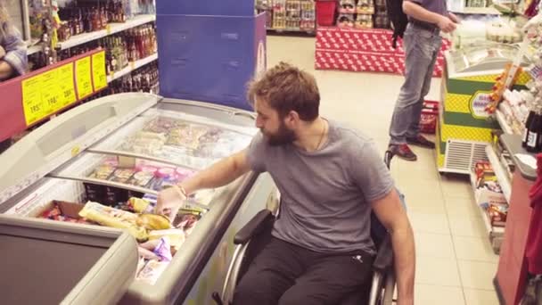 Un disabile in sedia a rotelle al supermercato — Video Stock