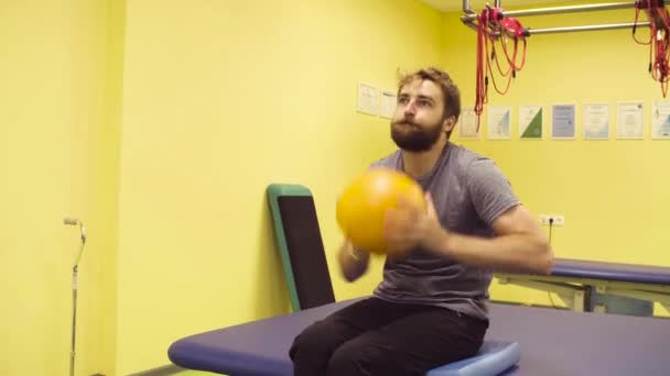 В реабилитационном центре спортсмен-инвалид делает упражнения для рук — стоковое видео
