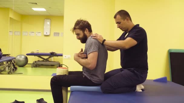Lékař pomáhá mladý muž v rehabilitačním centru — Stock video