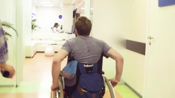 Een gehandicapte man in een rolstoel in het revalidatiecentrum — Stockvideo