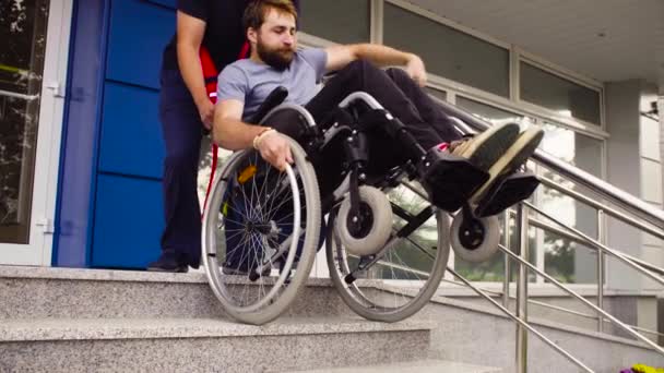 Człowieka, przyczyniając się do Przenieś w dół niepełnosprawny mężczyzna — Wideo stockowe