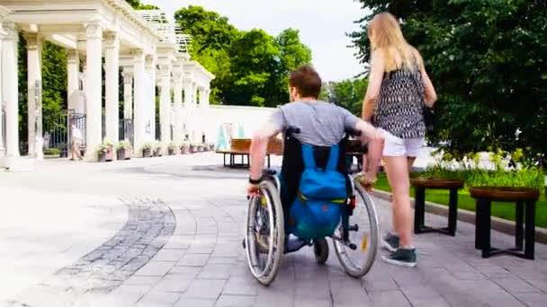 Joven hombre incapacitado caminando en el parque con su esposa — Vídeos de Stock