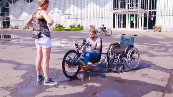 Feliz joven hombre incapacitado está sentado en bicicleta de mano — Vídeos de Stock