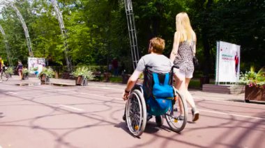 Genç karısı ile parkta yürüyen adam devre dışı