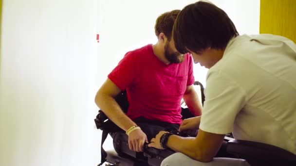 Doktor uvedení robotické exoskeletu pro zdravotně postižené muže — Stock video
