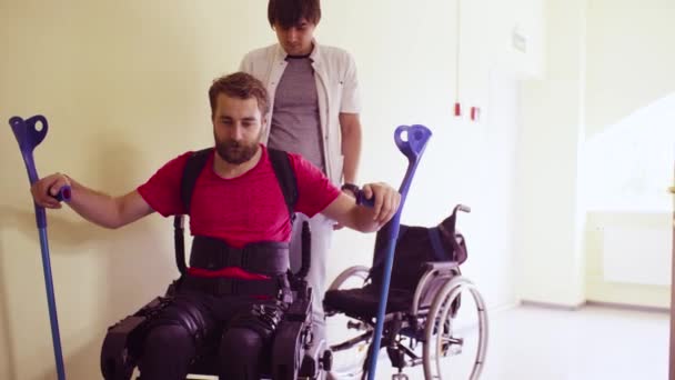 Молодой инвалид в роботизированном экзоскелете — стоковое видео