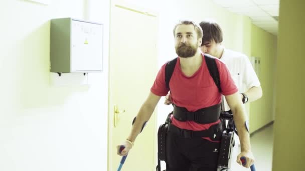 Young disable man walking in the robotic exoskeleton — Stock Video