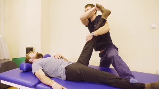 Médico haciendo ejercicios de estiramiento para el hombre incapacitado — Vídeos de Stock