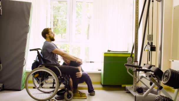 Инвалид в инвалидном кресле делает упражнения для рук — стоковое видео