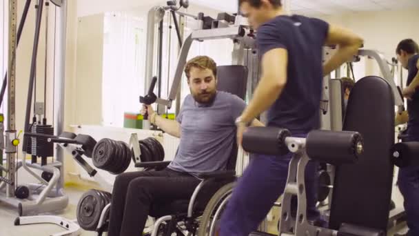 Behinderter Mann im Rollstuhl macht Handübungen — Stockvideo