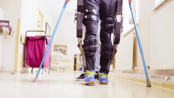 Jambes d'invalide en orthèse marchant avec le soutien de deux cannes à pied — Video