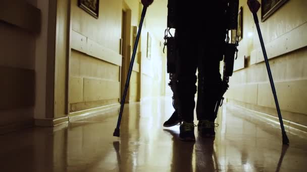 Beine von Behinderten in Roboter-Exoskelett durch den Korridor laufen — Stockvideo
