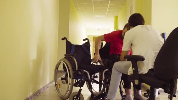 Молодой инвалид меняет скамейку на инвалидное кресло — стоковое видео