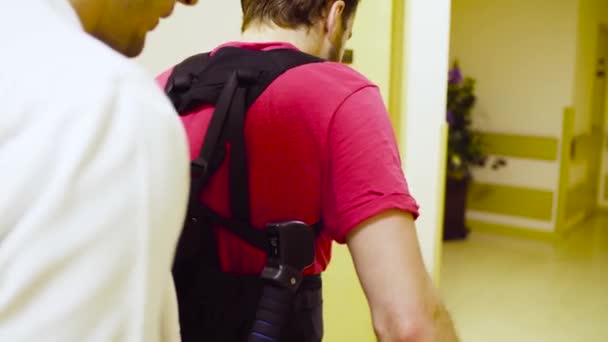 Jonge uitschakelen man lopen in robotic exoskeleton — Stockvideo