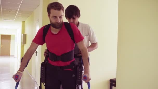 Jovem homem incapacitado andando no exoesqueleto robótico — Vídeo de Stock